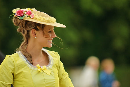 shallow focus photography of woman in yellow-green dress and hat during daytime
