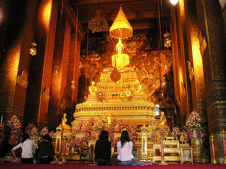 four people in front of Buddha altar