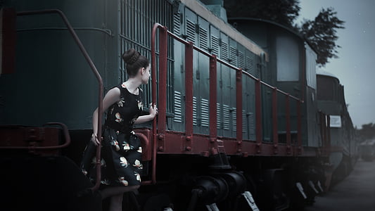 photo of woman standing on train stair