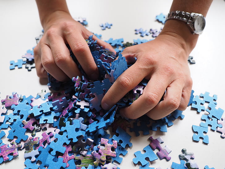 person picking jigsaw puzzles