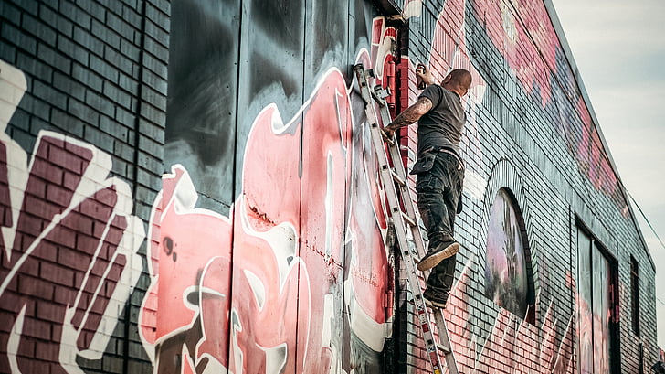 man spraying paint on wall