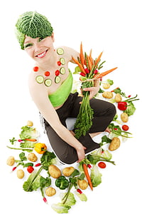woman in green bondeau and black pants while holding bunch of carrots