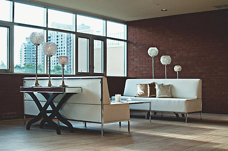 two white leather sofa on brown wooden parquet floor inside room