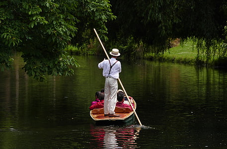 man rowing on boat with passengers sitting