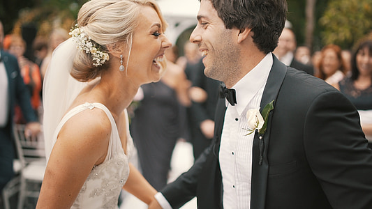 woman in white sleeveless bridal gown and man in black suit