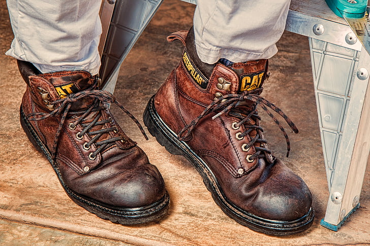 person in brown pants with brown Caterpillar leather work boots