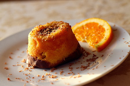 plate of orange chocolate pastry beside slide orange citrus fruit