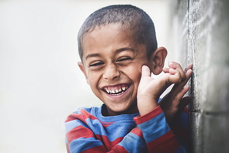 boy smiling leaning on wall