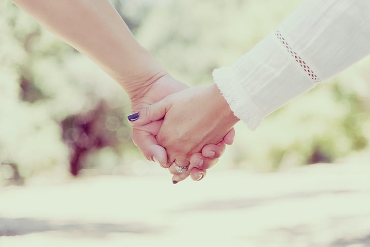 selective photography of couple holding hands
