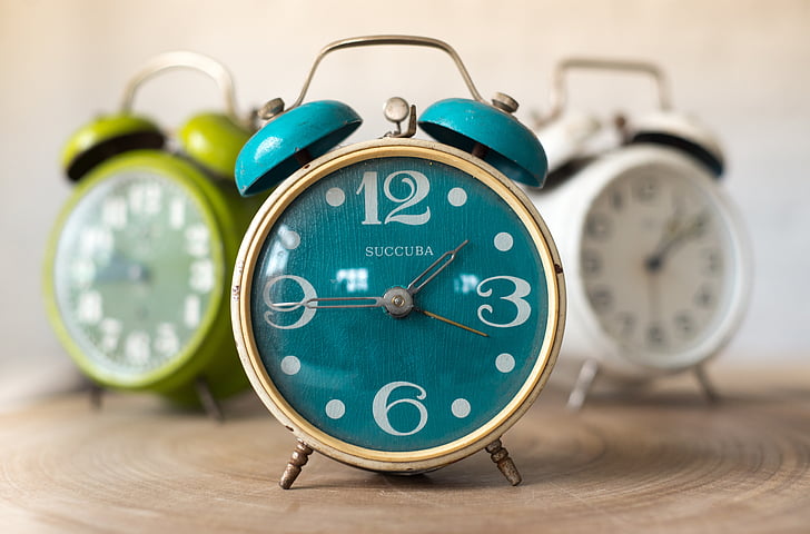 three assorted-color twin bell alarm clocks