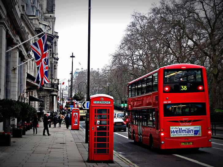 red double decker bus and red phone booth in street