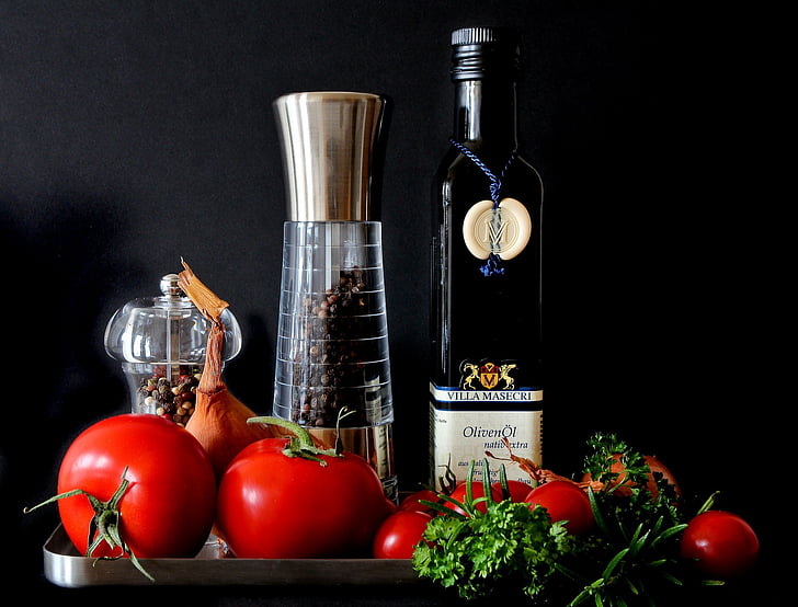 black glass wine bottle with red tomatoes on stainless steel tray