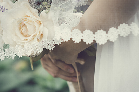 close-up photography of woman holding white rose flower bouquet