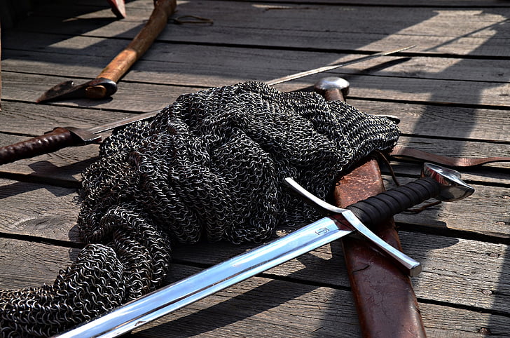 chainmail and long sword on wooden panel