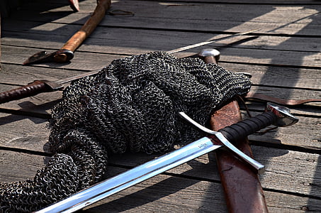 chainmail and long sword on wooden panel