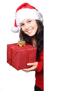 girl wearing Santa hat and holding red gift box