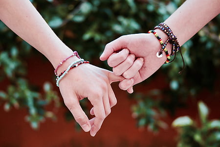 shallow focus of two person holding hands