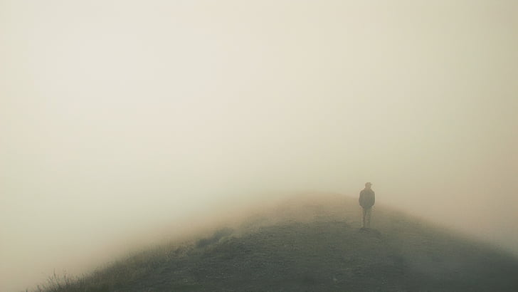 Royalty-Free photo: Person standing on a foggy mountain | PickPik