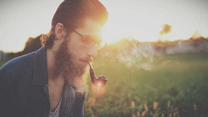selective focus photography of man using smoking pipe