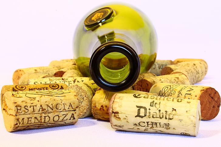 green wine bottle with assorted wine corks