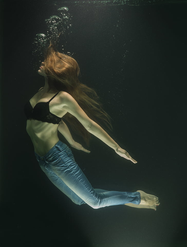 woman wearing blue jeans in body of water
