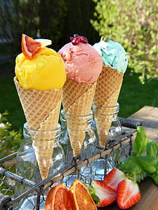 three assorted-color ice cream beside strawberry and grapefruit at daytime