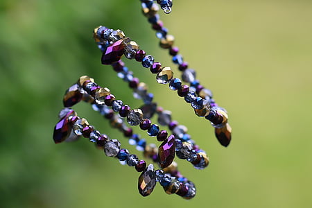 selective focus photography of purple, grey, and gold-colored beaded bracelet