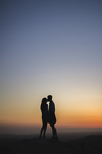 silhouette of man and woman kissing photo