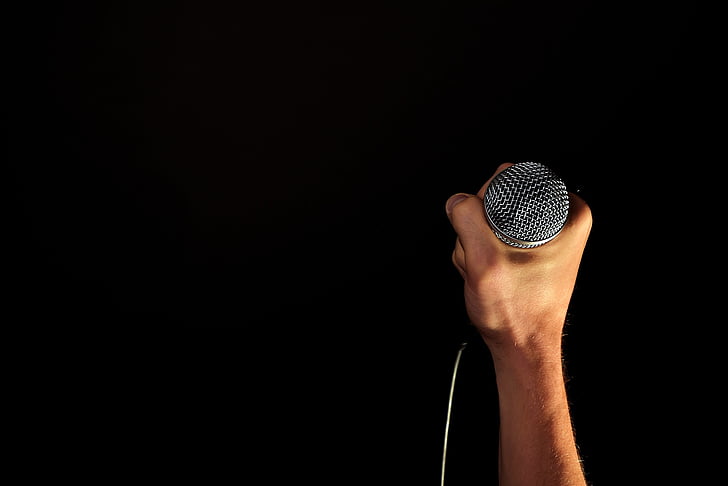person holding corded microphone
