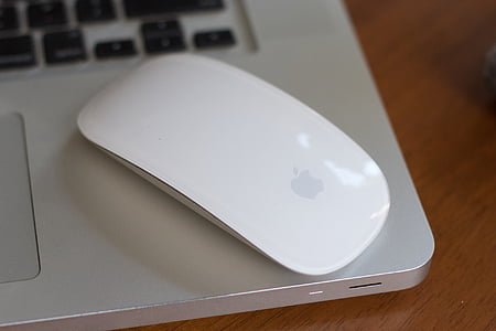 photo of Apple Magic Mouse on top of laptop