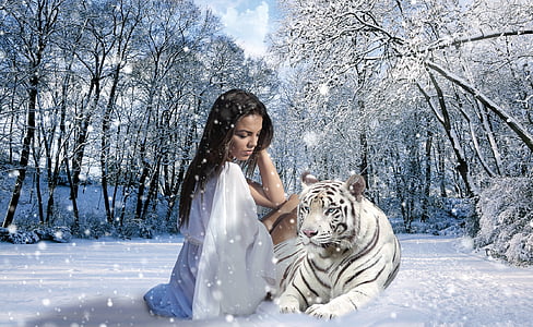 woman seats beside Tiger during snow season