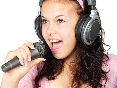 woman wearing gray headphones holding microphone