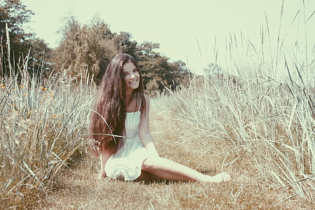 woman wearing white dress sitting on the grass