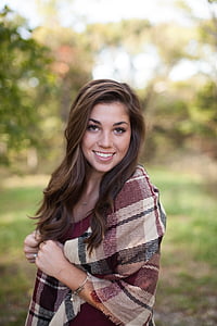 selective focus photography of woman wearing brown and black plaid scarf