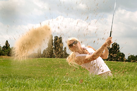 photograph of woman holding golf driver in green grass field