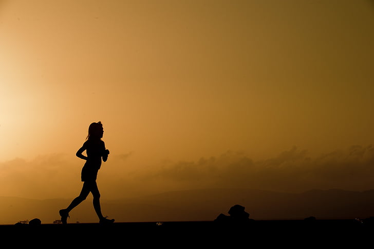 silhouette of woman running during golden hour