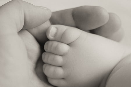 person holding baby's foot
