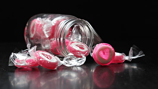 clear mason jar filled with round pink candies