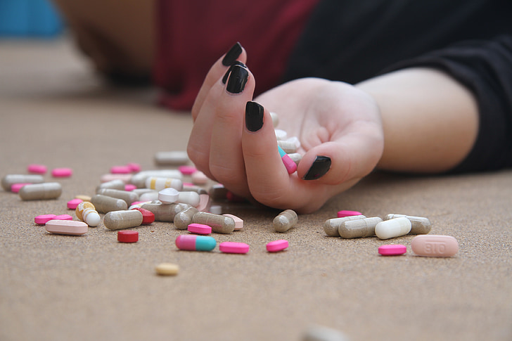 person hand holding medication pills