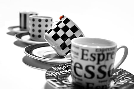 selective focus photography of white and black checked ceramic teacup on saucer