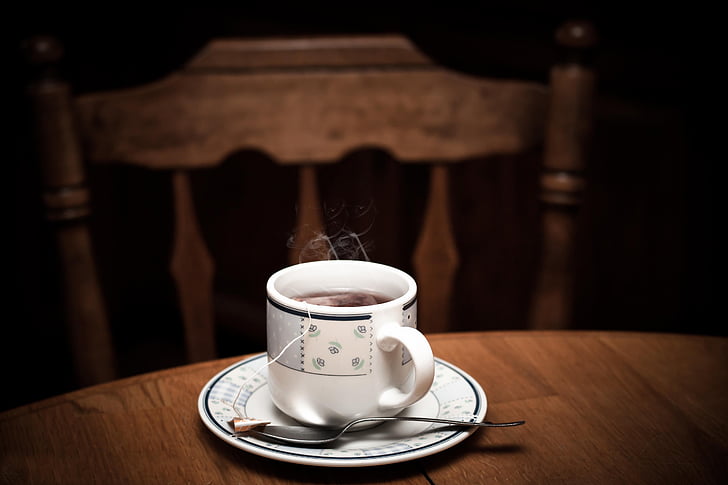 selective focus photo of white teacup with saucer on table