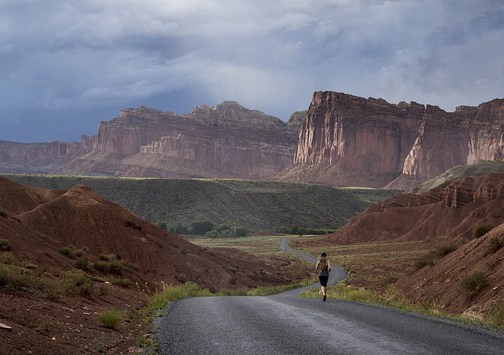 man running in road near mountain at daytime