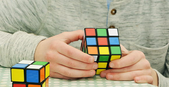 person holding 3 by 3 Rubik's cube