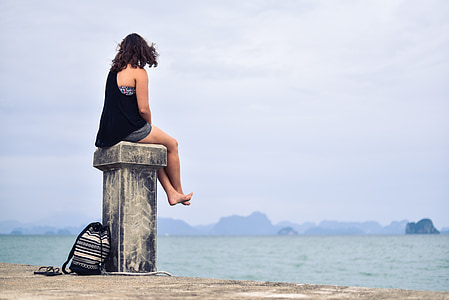 woman sitting near ocean photo