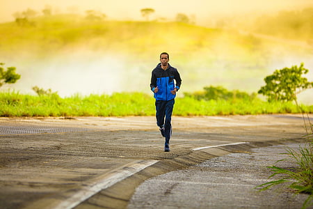 man wearing blue and black jacket and pants running on road
