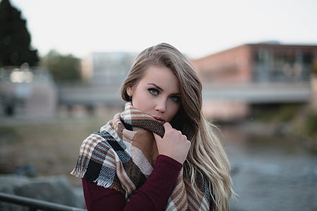 woman wearing marono long-sleeved top and white and brown plaid scarf taking photo during daytime