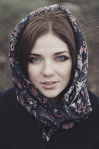 woman wearing blue, beige, and pink floral head scarf and black jacket