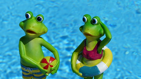 two green frog near body of water figurines