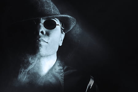man in round hat with smoke and sunglasses