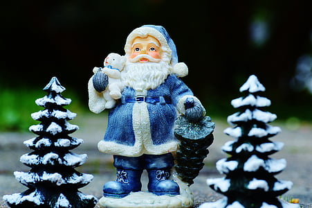 Santa Claus figurine between Christmas tree figurines